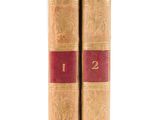 two old books sitting on top of each other on a white surface