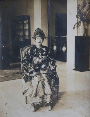 une vieille photo d'une femme assise sur une chaise