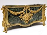 a gold and green box with a floral decoration on it
