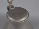 an old silver vase with a lid on a white surface