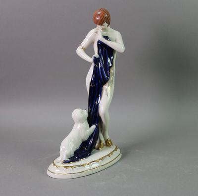 une figurine représentant une femme et un chien posée sur une table