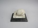 statue représentant un chat endormi sur un socle en marbre