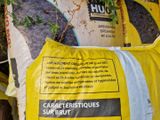 un sac de ciment à côté d'un tas de plantes