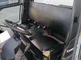 a man sitting in a vehicle with a laptop on his lap