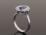 a blue sapphire and diamond ring on a reflective surface