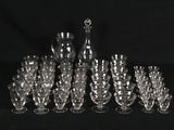 many glasses and a decanter on a black background
