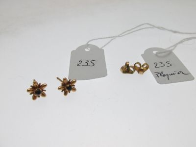 trois boucles d'oreilles en or et une étiquette sur laquelle figure le prix