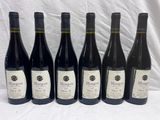 six bouteilles de vin sont alignées sur une table