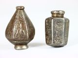 deux vases en argent posés l'un à côté de l'autre sur une surface blanche