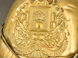 a gold bell with a bird on top of it
