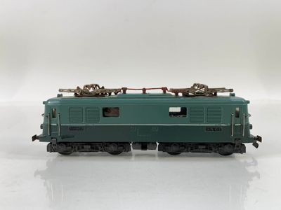 a green train car sitting on top of a white surface
