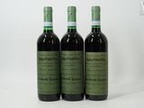 trois bouteilles de vin posées les unes à côté des autres sur une surface blanche