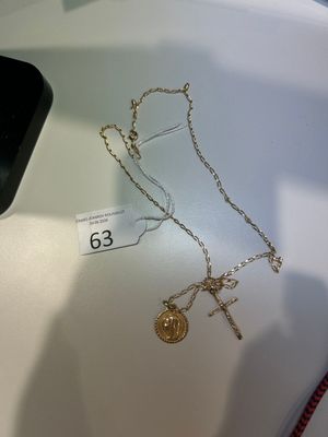un collier en or orné d'une croix et d'une pièce d'or