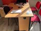a desk with two chairs and a computer on top of it