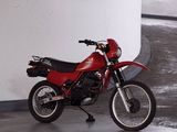 a red motorcycle parked in a parking garage