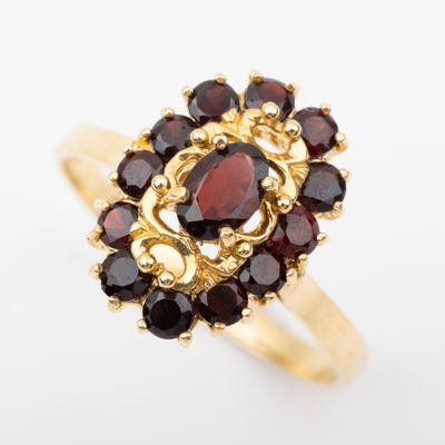 Gros plan sur une bague en or ornée de grenats