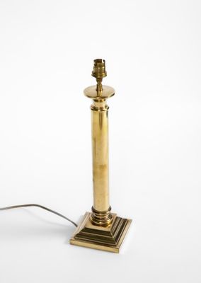 une lampe de table en laiton ancien sur fond blanc