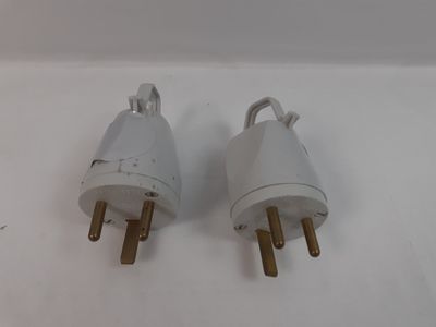 une paire de prises électriques blanches posées sur une surface blanche, avec un fond blanc