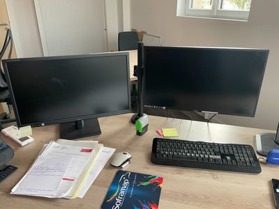 un bureau sur lequel sont posés deux écrans d'ordinateur et un clavier