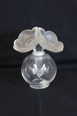 a glass vase with a flower on top of it