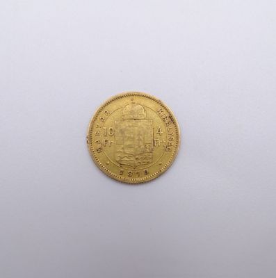 gros plan d'une pièce d'or sur une surface blanche