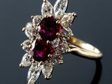 un gros plan d'une bague sertie d'un diamant rouge et blanc sur une surface noire