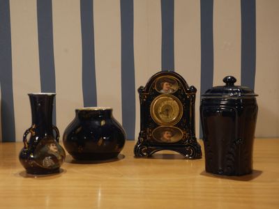 trois vases et une horloge posés sur une table