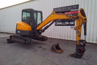 an image of a small excavator parked in front of a building