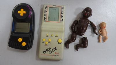 un jouet d'un bébé assis à côté d'une manette de jeu