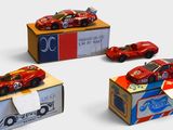trois petites voitures sont posées sur une boîte en carton