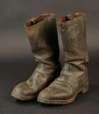 an old pair of brown boots sitting on top of a black surface