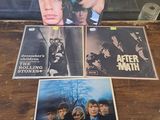 the rolling stones album covers are sitting on a table in front of a glass case