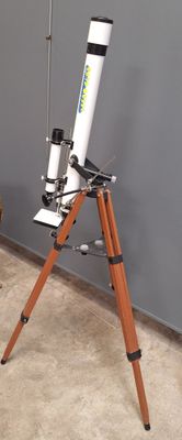 un télescope posé sur un trépied dans une pièce