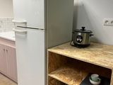 a small kitchen with a white refrigerator and a wooden counter