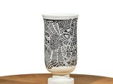 a black and white vase sitting on a wooden table