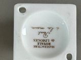 a small white plate with a picture of a man on it