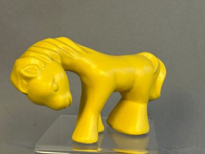 un cheval jaune qui se tient debout sur une table