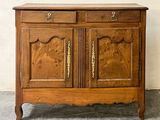 une armoire en bois dont les portes et les tiroirs sont sculptés