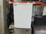 an image of a refrigerator in a warehouse with other appliances