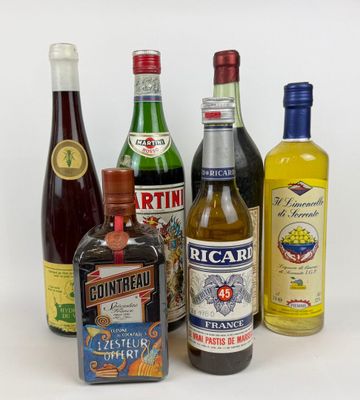 plusieurs bouteilles d'alcool sont alignées sur une surface blanche