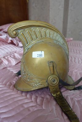 un casque doré posé sur un lit recouvert d'une couette rose