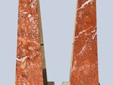 pair of red marble obelisks with black bases on a gray background
