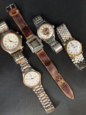 trois montres sont posées les unes à côté des autres sur une surface noire