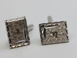 pair of silver cufflinks with a square cut design