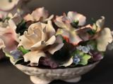 a white vase with flowers in it on a table