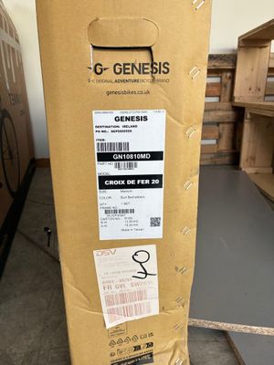une boîte en carton sur laquelle est collée une étiquette, posée par terre