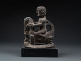 an image of a statue of a woman sitting on a rock