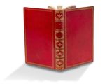 un vieux livre rouge aux tranches dorées et à la couverture rouge