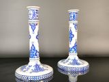 two blue and white vases sitting on a black table
