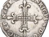 a silver coin with a cross on the front of it
